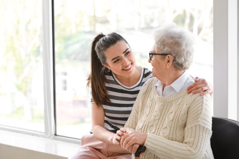 caregiver with senior woman in front of a glass wall