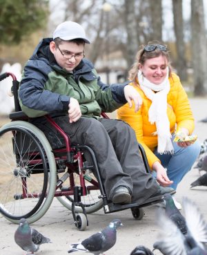 Belarus, Gomel, on April 11, 2018. City Day. Central Park.A man in a wheelchair with his wife is feeding pigeons